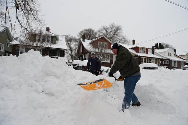 BUFFALO, NY - DECEMBER 26: Dave and Rowan Garry clear their driveway driveway on December 26, 2022 in Buffalo, New York. The historic winter storm Elliott dumped up to four feet of snow on the area leaving thousands without power and at least twenty five confirmed dead in the city of Buffalo. (Photo by John Normile/Getty Images)