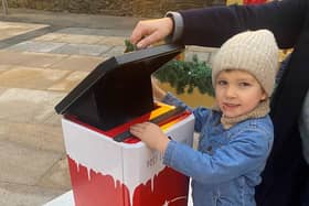 Derry youngster Cahan McKinney posts his letter to Santa in Guildhall Squar