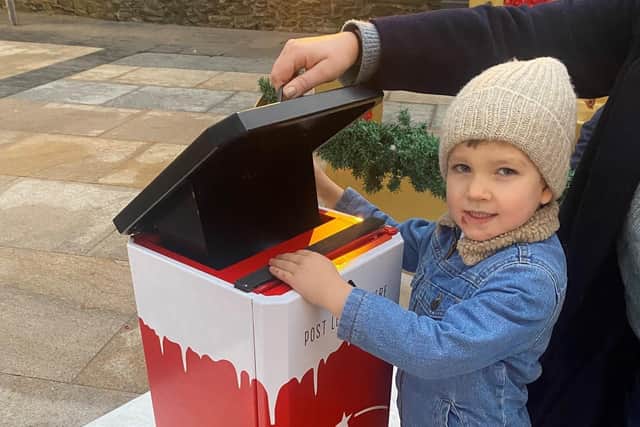 Derry youngster Cahan McKinney posts his letter to Santa in Guildhall Squar