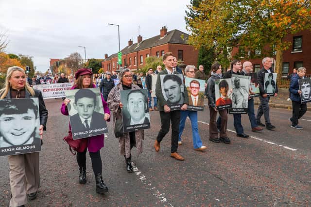 Family members and supporters of those killed on Bloody Sunday, hold photos of those killed as they walked towards Belfast Crown Court last year. (Photo by Paul Faith / AFP) (Photo by PAUL FAITH/AFP via Getty Images)