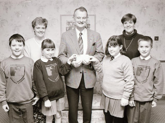 Foyle Hospice founder Dr Tom McGinley receiving a cheque from Lisnagelvin PS pupils.