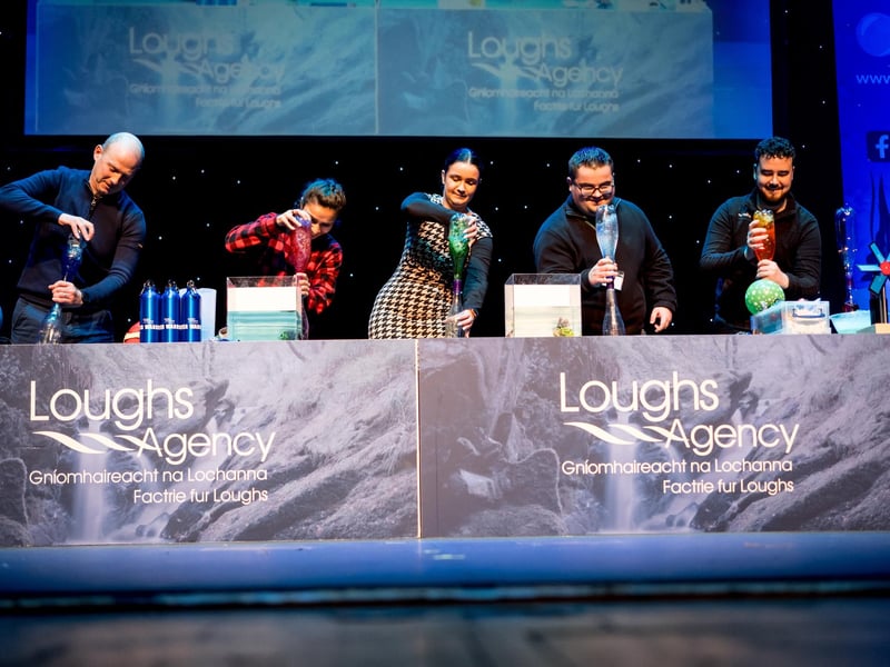 Teachers compete onstage in a Tornado Twister game