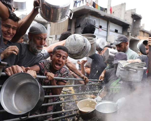 Palestinians struggle to get their food rations outside a crowded distribution centre in Beit Lahia in the northern Gaza Strip on May 15, 2025. Gaza rescuers said Israeli strikes and shelling on Thursday killed 82 people in the war-battered Palestinian territory, updating a previous toll. (Photo by BASHAR TALEB / AFP) (Photo by BASHAR TALEB/AFP via Getty Images)