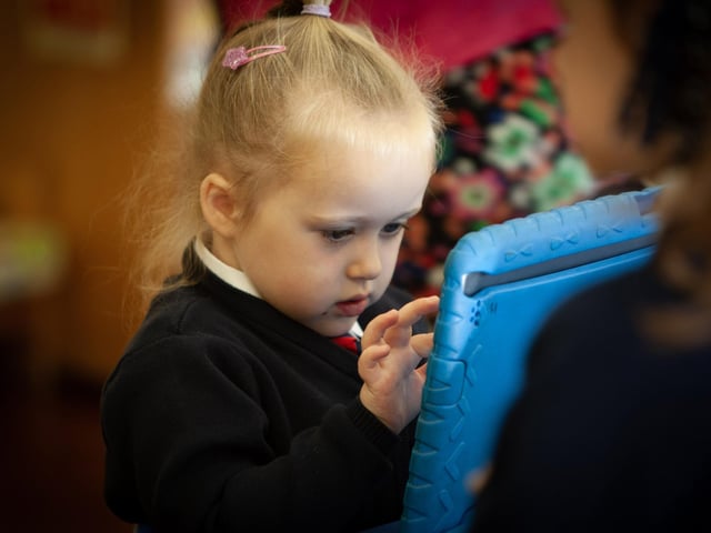 Primary 1 pupil Riley has total concentration on her ipad at Holy Child PS.