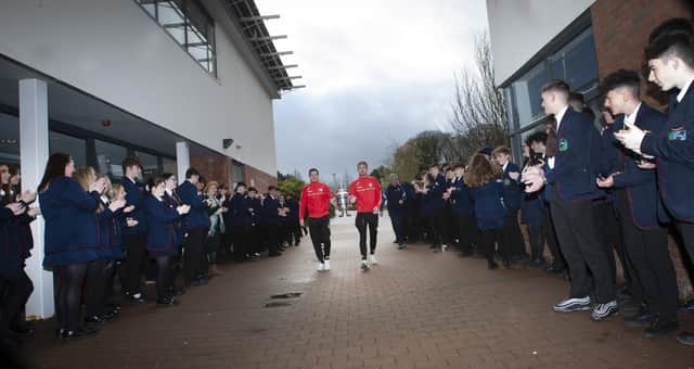 Derry City players Ciaran Coll and Jamie McGonigle get a guard of honour as they arrive at Oakgrove Integrated College with the FAI Cup.