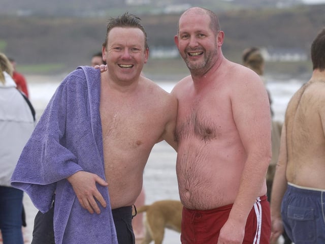 Vincent McAuley, left, and Laurence Pedlow begin to thaw out. (0301PG14) : Culdaff New Year's Day Swim in 2006.