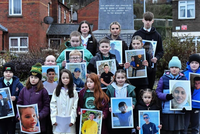 Fourteen young relatives of those murdered on Bloody Sunday carry photographs of children from the West Bank killed by the Israeli military, at the one minute silence dedicated to the children of Gaza at the Bloody Sunday monument yesterday afternoon. Photo: George Sweeney