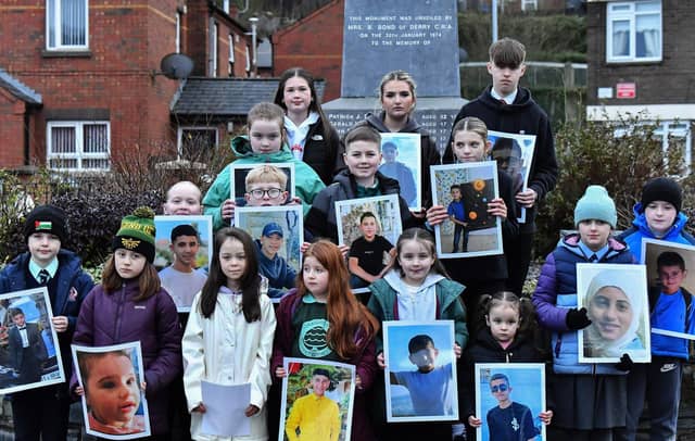 Fourteen young relatives of those murdered on Bloody Sunday carry photographs of children from the West Bank killed by the Israeli military, at the one minute silence dedicated to the children of Gaza at the Bloody Sunday monument yesterday afternoon. Photo: George Sweeney