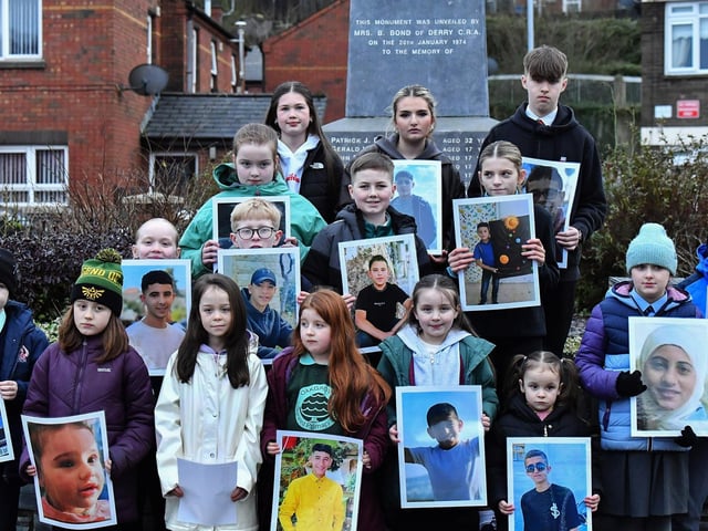 Fourteen young relatives of those murdered on Bloody Sunday carry photographs of children from the West Bank killed by the Israeli military, at the one minute silence dedicated to the children of Gaza at the Bloody Sunday monument yesterday afternoon. Photo: George Sweeney