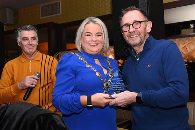 The Mayor, Sandra Duffy, presenting Mark Caithness with a congratulatory acknowledgment as Felix Healy looks on.