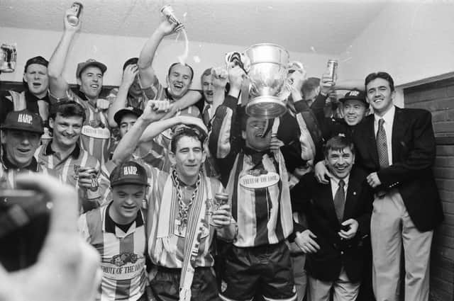 Derry City captain Dermot O'Neill raises the FAI Cup as the players celebrate in the changing room following their 2-1 win over Shelbourne in the 1994/95 final.