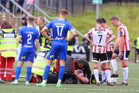 Shane McEleney looks on as his brother Patrick is treated on the pitch after breaking  his elbow. Photograph by Kevin Moore.