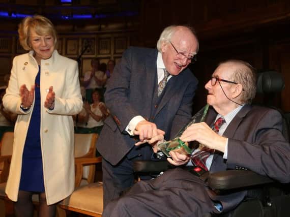 President Michael D. Higgins presents and award to Ivan Cooper as his wife Sabina looks on.