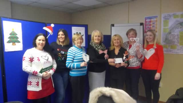 Pat Harper, with Ethna Mc Cullagh and Mary Casey,  of Culmore Handcrafters is presenting the cheque to Ciara Ferguson of Greater Shantallow Area Partnership on behalf of the Ethos Family Support Hub.
