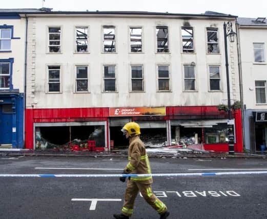 A fireman waks past the Poundstretcher premises on Bishop Street  after a fire gutted the three storey premises in July 2015. DER2815MC059