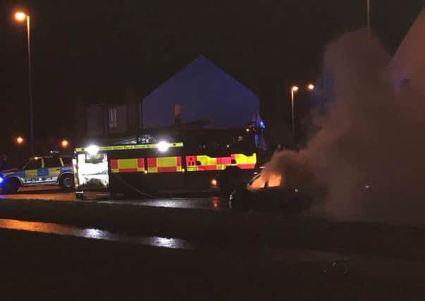Smoke billowing from the vehicle as emergency services attend the scene.