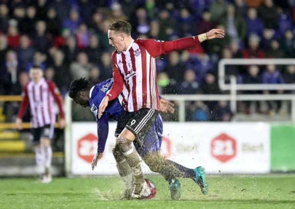 Ronan Curtis and Waterford's Stanley Aborah struggle with the conditions at a rain-sodden RSC.