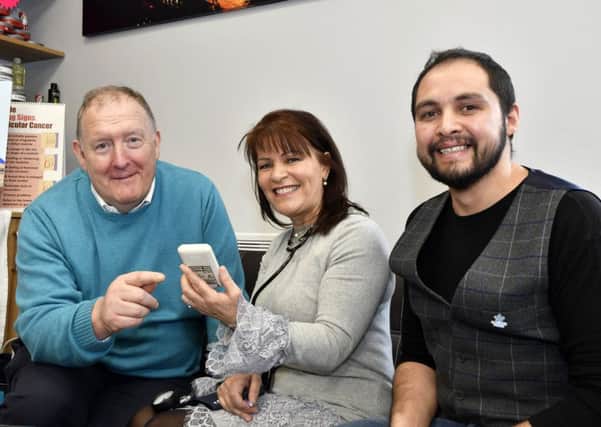 Pat Ramsey has his blood sugars checked by Margaret Cunninghan of Healtheee during the Men's Health Day at the City Turkish Barbers on Friday. Included is Merwan Aytas, barber. DER1018-103KM