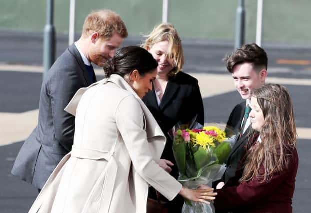 Prince Harry and Megan Markle are greeted on their arrival in NI by Derry schoolkids, Amber Hamilton and Ryan McCallion.