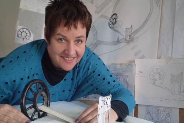 Artist Louise Walsh with some of her designs for the sculpture.
