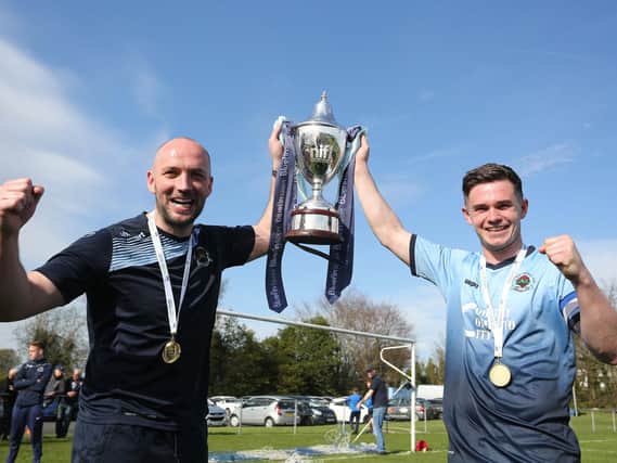 Institute manager Paddy McLaughlin along with skipper Michael McCrudden hold aloft the Bluefin Sport Championship trophy.