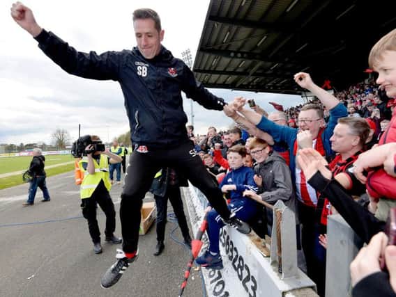 Crusaders manager, Stephen Baxter celebrates his third league title success at the Ballymena Showgrounds on Saturday,