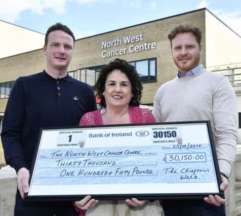 Bernie McGuinness, with her sons Emmet, right and Fiachra with the cheque for Â£30,150.00, proceeds from the recent Chieftains Walk in memory of Martin McGuinness, which was handed over to The North West Cancer Centre at Altnagelvin Hospital on Monday. DER1818-104KM