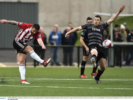 Derry City striker, Rory Patterson sends in a shot as Brian Gartland - scorer of Dundalk's equaliser - attempts to block.