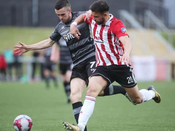 Derry City's Darren Cole tussles with Dundalk winger Michael Duffy.