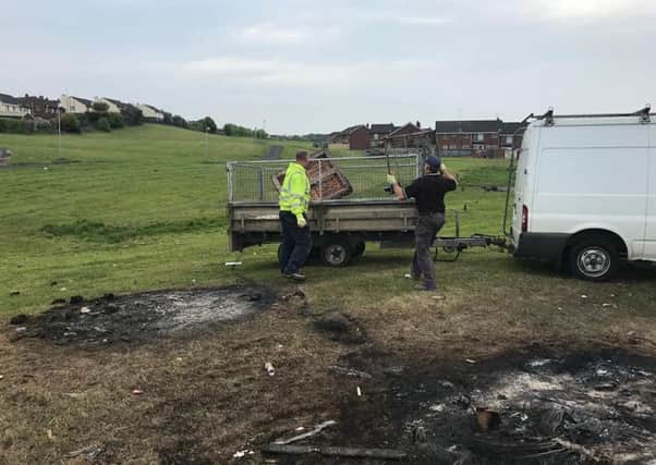 Workers at the site of the recent bonfires in Galliagh.
