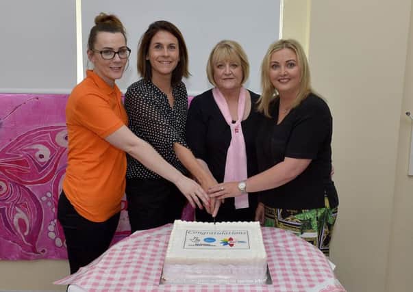 Michelle McLaren, Judith McCann, Angela McGowan and Karen Mullan MLA cutting a cake at the Pink Ladies Big Lottery Award celebration day, earlier this week, in Bishop Street Community Centre. DER2118GS003