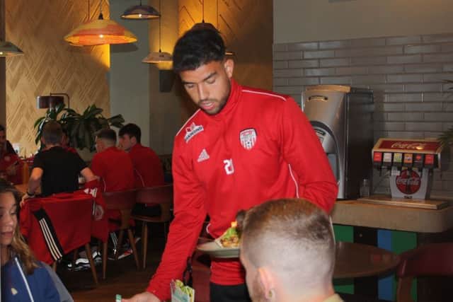 Derry City defender, Darren Cole pictured serving food at Nandos Restaurant for charity.