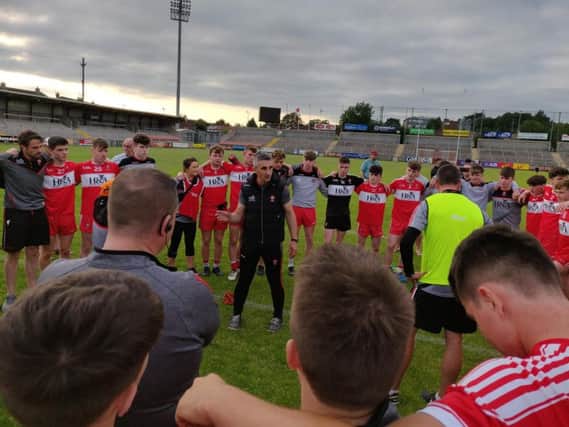Derry manager Paddy Campbell talks to his players after Sunday's victory.
