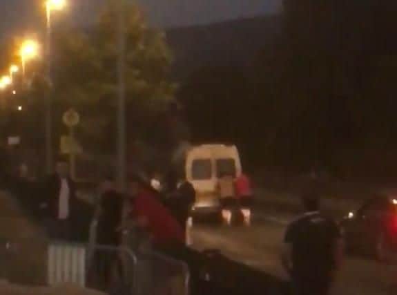 Members of the Red Partisans Supporters Club give their mini-bus a push outside Tallaght Stadium.