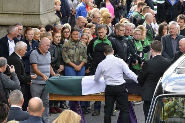 AodhÃ¡n O'Donnell Â‘s father Gerry and brother Sean remove the Na Magha from his coffin at St EugeneÂ’s Cathedral yesterday morning. DER2918GS010