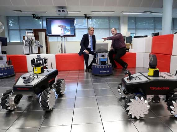 Philip Hammond (left) is shown a robot by Emmett Kerr, a lecturer in mechanical engineering, during his visit to Magee.