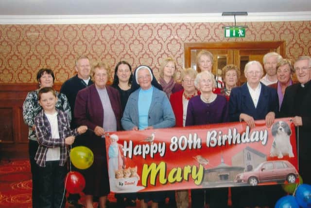 Mary with Fr Neil McGoldrick, family and friends at her 80th birthday party at An Grianan Hotel