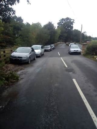 Cars parked alongside the bridge at Claudy.