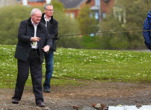 The late Martin McGuinness, pictured here casting a line out during canvassing with Gerry Kelly in Belfast in 2015. (Picture - Kevin Scott / Presseye News)