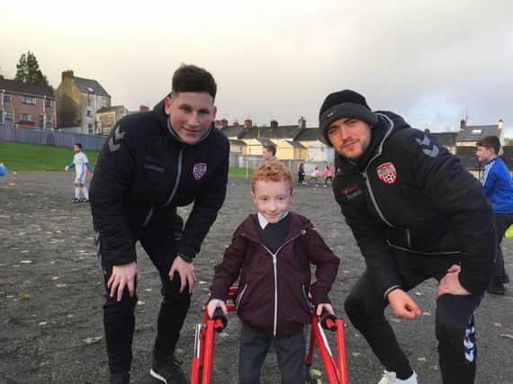 Cianin Campbell (10) with Derry City Football players Conor McDermott and Dean Jarvis during a football session as part of a pilot scheme in The Model Primary Scheme run by The Ryan McBride Foundation last year.