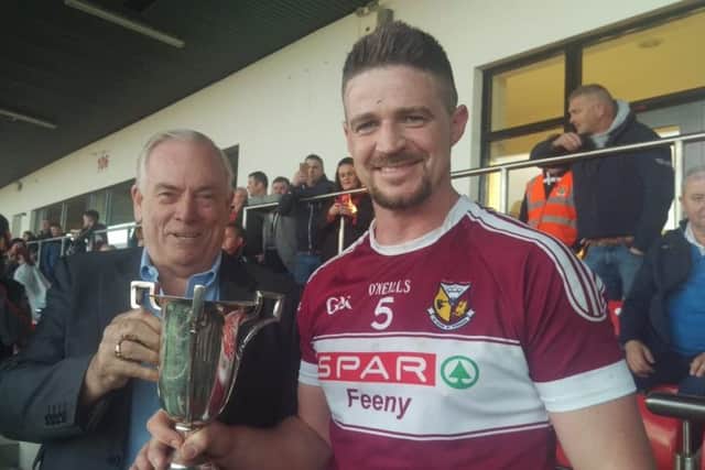 Banagher captain Paul Cartin receives the Intermediate Championship trophy after St Mary's defeated Ballymaguigan on Saturday.