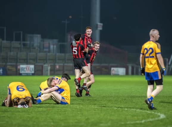Red Hugh's Peader McGlinchey, Johnny Carlin and Stephen McMenamin celebrate their Ulster Junior Championship Final victory while distraught Limavady Wolfhounds players slump to the ground in Celtic Park on Saturday. DER4618GS035