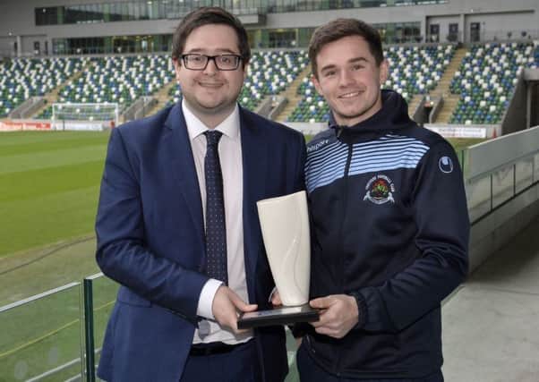 Institute striker Michael McCrudden collects his Belleek trophy from NIFWA Chairman Keith Bailie.