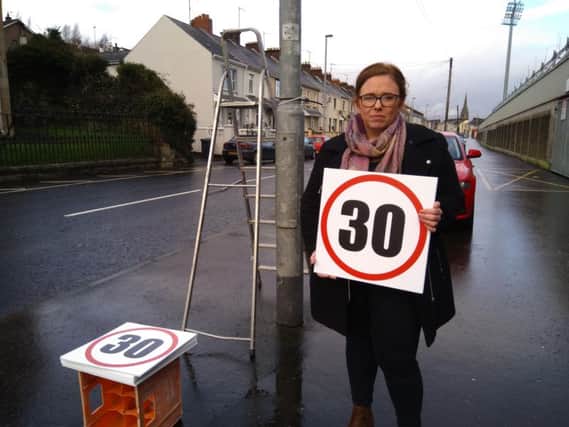 Sinn Fein Councillor Sharon Duddy pictured at the weekend on the Lonemoor Road as the signs were being erected.