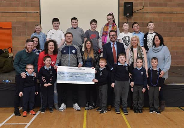 AJ and Mary Jane McClean present a cheque donation for £500, on behalf of James McClean, to Ardnashee School and College PE teacher Eamon Colhoun. Included in the picture are acting Principal Mr Raymond McFeeters, pupils, staff and parents. The generous donation is a contribution towards equipping a new gym. DER0519GS-029