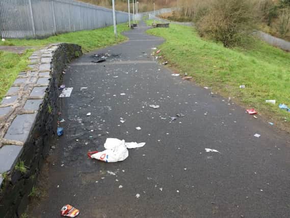 Pathway strewn with broken glass and rubbish