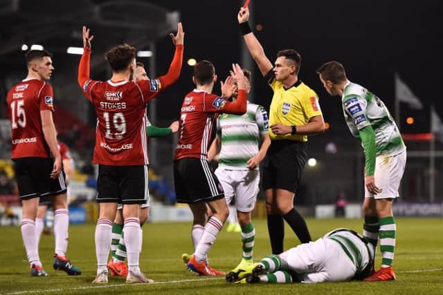 Referee Robert Hennessy shows a red card to Jamie McDonagh