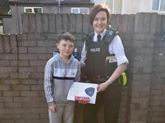 Tiernan McCready receiving his badge of honour from a local PSNI officer.