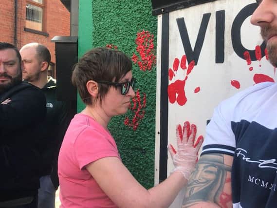 Friends of murdered journalist Lyra McKee put red handprints in a wall of the dissident republican office in Derry with red paint. (Cate McCurry/PA Wire)