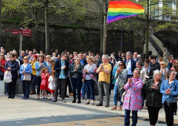 People applaud at a vigil for Lyra McKee, in Guildhall Square.